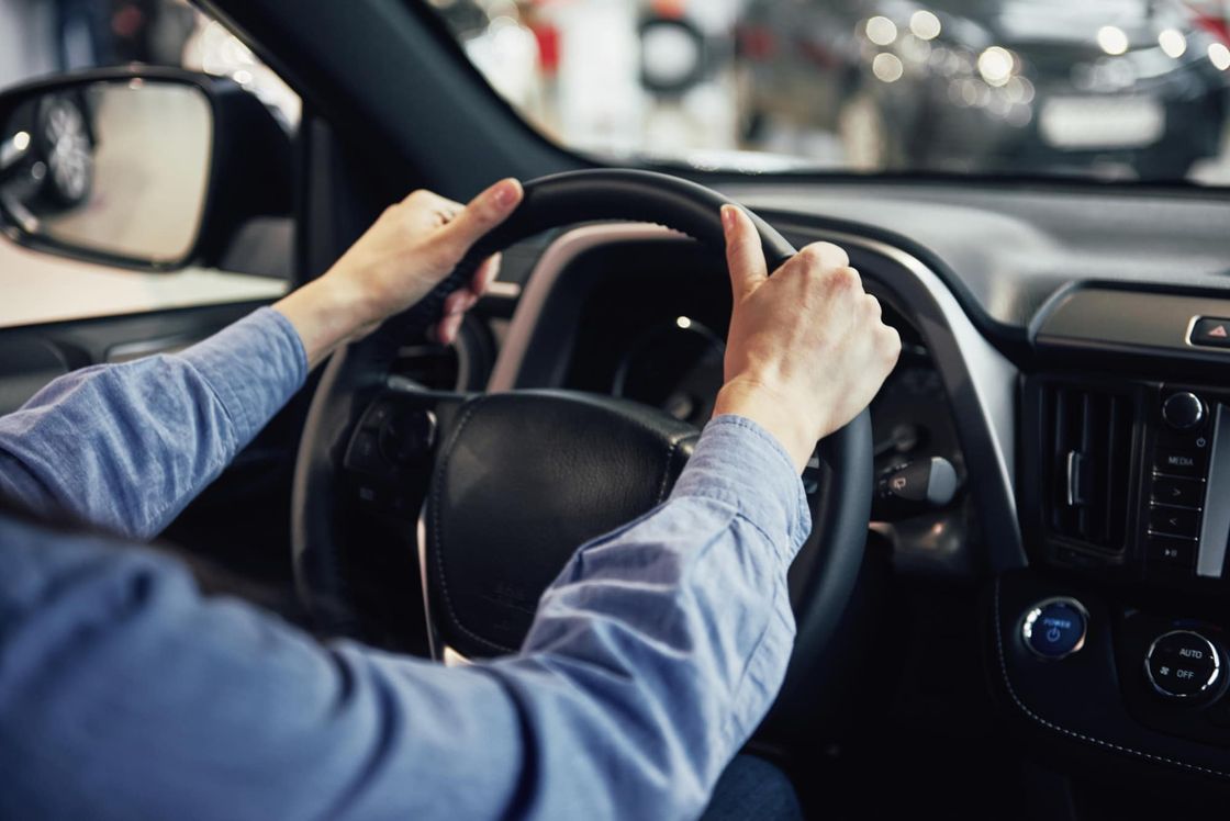 Driver's hands on the steering wheel