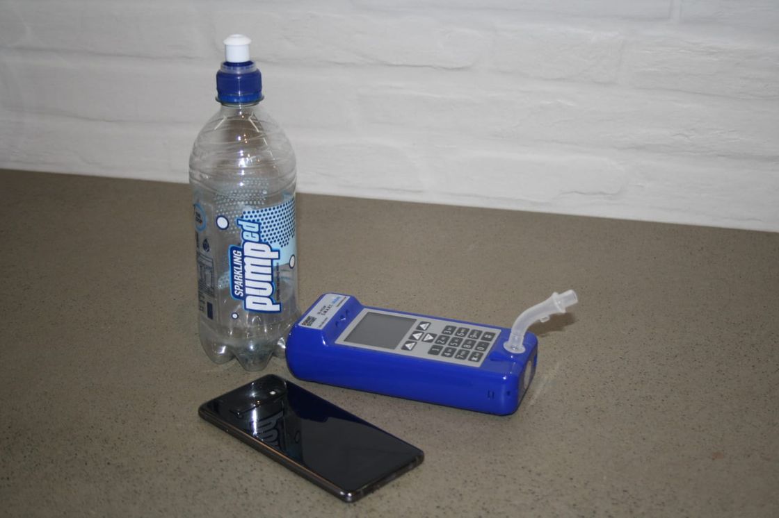 Smart Mobile device next to a phone and water bottle