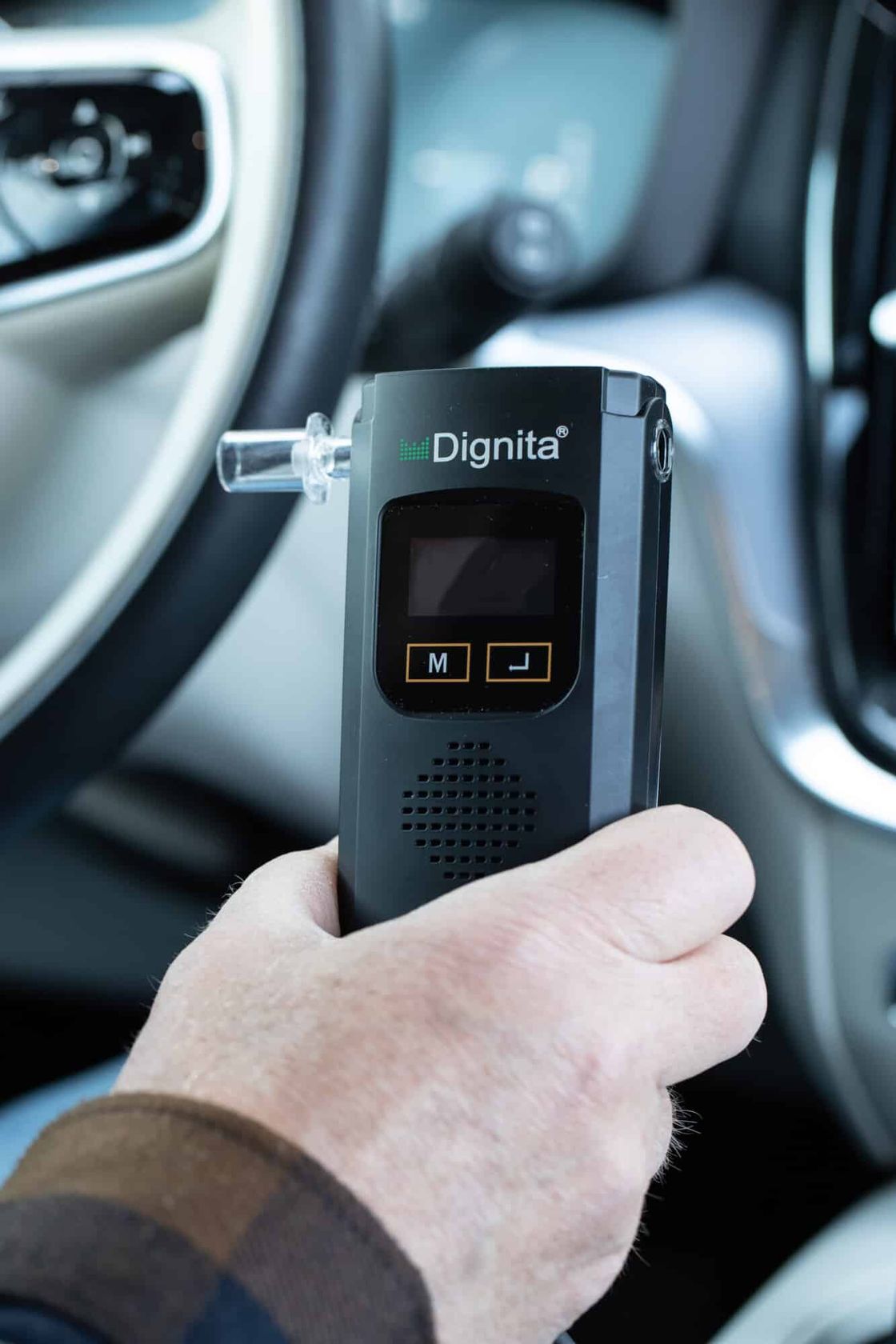Driver holding a Dignita interlock in a car